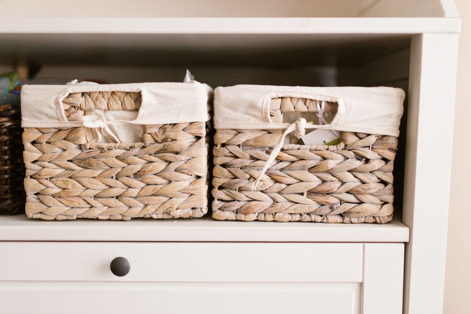 Étagère ouverte bien ordonnée avec paniers, boîtes déco et objets choisis dans un salon lumineux